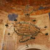 Alzando lo sguardo ci accorgiamo che proprio dal centro della calotta scende verso le nostre teste un curioso e affascinante lampadario in ferro, un tempo padrone assoluto dell�ambiente che accoglieva i fedeli in preghiera, oggi deformato dall�umidit� e dalla salsedine